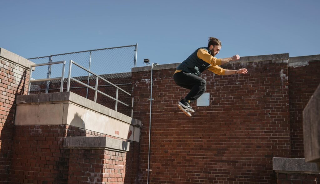 A focused parkour athlete skillfully leaps between urban structures showcasing agility and strength.