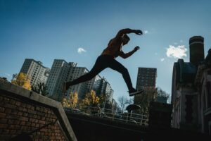 Man performing parkour jump between buildings in the city.